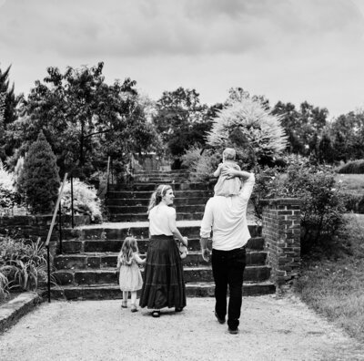 black and white image of family walking through the garden