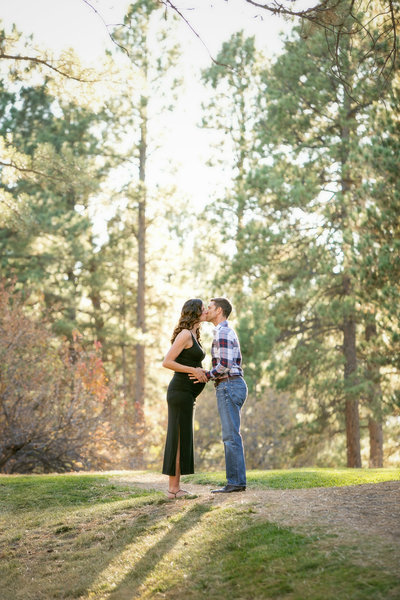 Pregnant couple pause for a romantic kiss while hiking Bonnie Brae