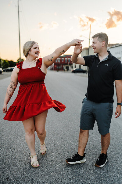 Engaged couple dancing in Wisconsin street at sunset.