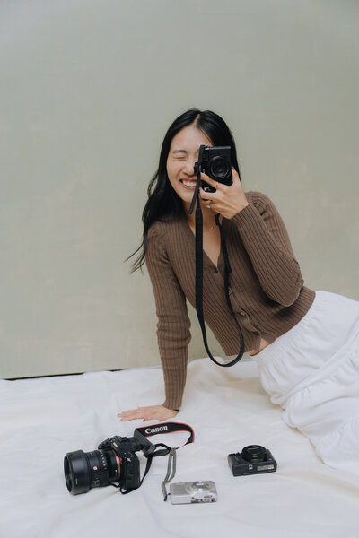 girl holding up camera and smiling