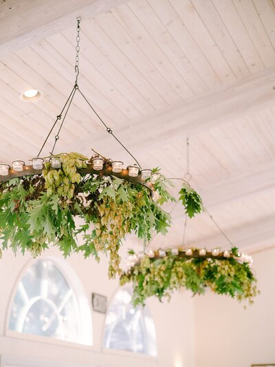 A wedding reception adorned with lush greenery and hanging plants, creating a natural and elegant ambiance.