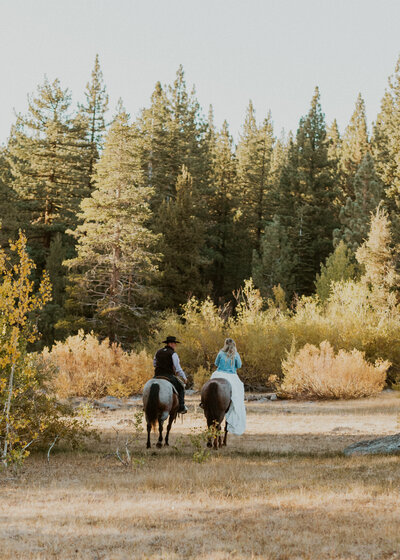 Couple riding into the forest side by side after eloping and saying I do