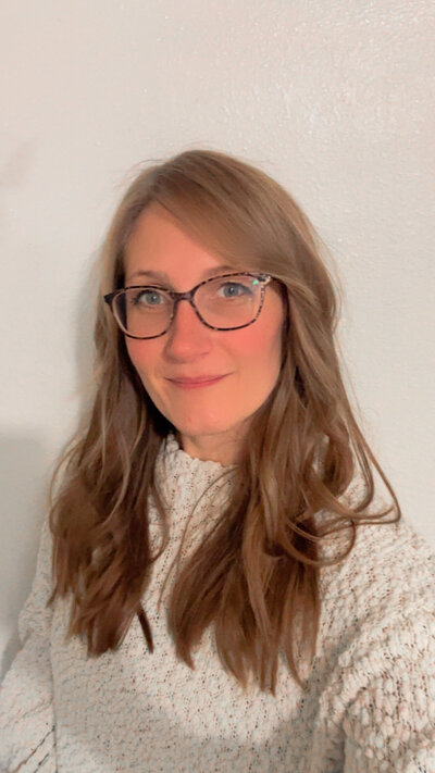 Jazzmine a hair stylist in Eugene smiles at the camera.