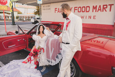 bride and groom in classic red car after elopement ceremony