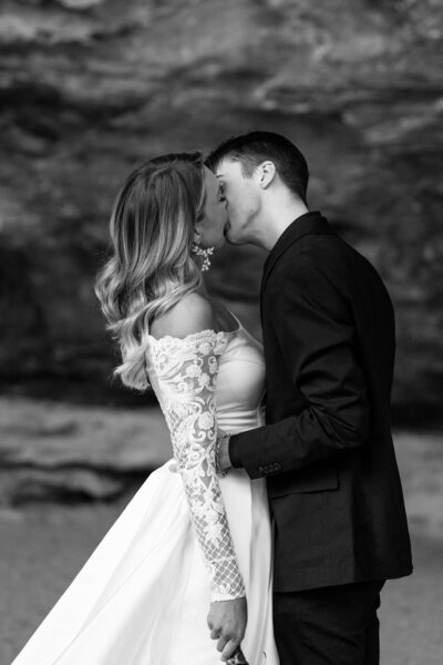 Bride holding up a bouquet of flowers during a beach elopement in Michigan.