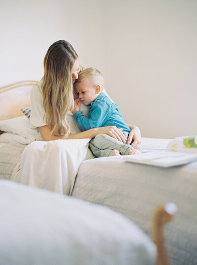 Mother and son cuddling on bed