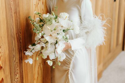 photo of bride and groom sitting in a boat in the water with mountains in the distance while they embrace taken by Elopement photographer Jackson Hole