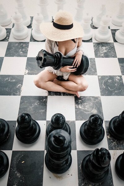 Woman holding the queen on a chess board