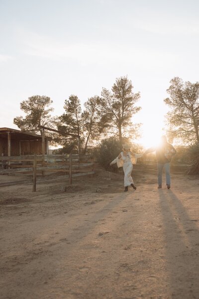 family of three walking outdoors at yucca valley california ranch golden hour