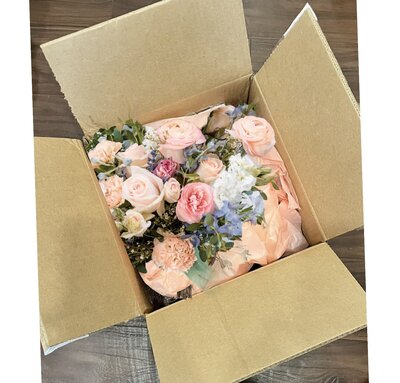 groom sitting next to bride holding bright and beautiful bouquet made by Buds Blooms and Blossoms