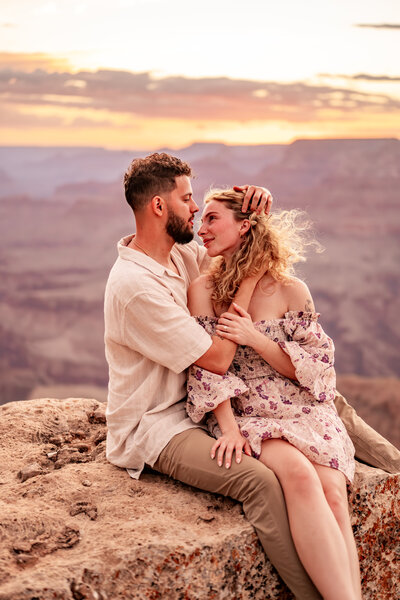 Couple in silhouette during a sunset proposal at the Grand Canyon, with golden light casting a romantic glow over the scene