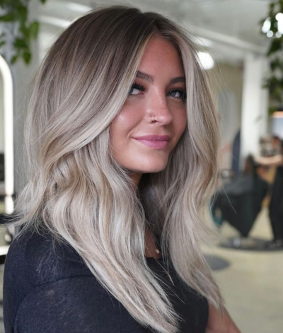 Woman with ash blonde waves styled with expert balayage techniques at Salon Beau.