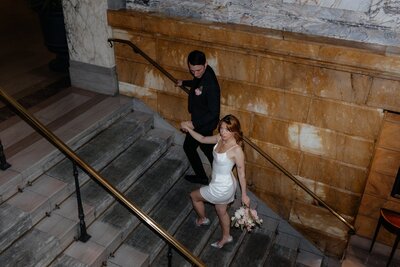 bride and groom walk up the stairs of their wedding venue in texas