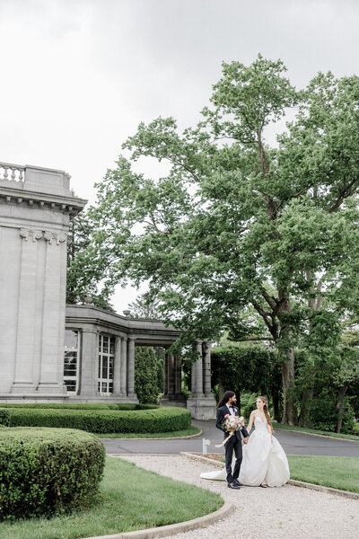 A Bride and groom walking in front of Laurel Court residence, photographed by Kaitlin Mendoza Photography,  Indianapolis wedding photographers