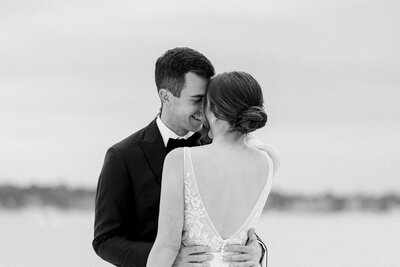 Elopement Photographer,  a recently married bride and groom embrace face to face on the beach