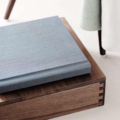 A blue linen album with a custom wood box to store the heirloom album