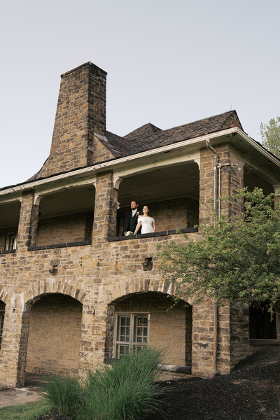 A bride and groom walking after their wedding ceremony in Austin, Texas. The bride is holding her flowers, the groom is holding her dress. 