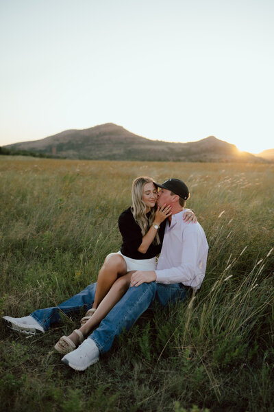 couple sitting in field at oklahoma couples session