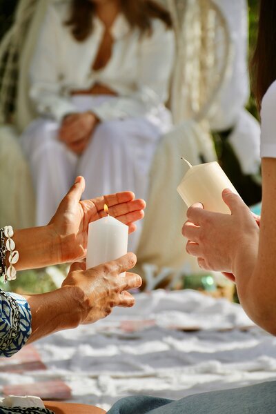 Zwei Frauen halten weisse Kerzen in der Hand