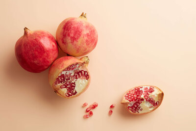 three pomegranates on a counter