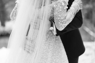 Black and white portrait of a groom holding the bride with her veil draped over his hands captured as an intimate wedding moment in Banff National Park by Calgary wedding photographer Geoff Wilkings