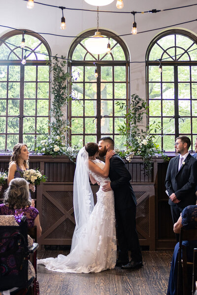 Stunning circular wedding arch decorated with vibrant flowers and foliage by Leigh Florist, perfect for a modern outdoor ceremony