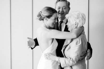 a bride hugging her grandmother while her grandfather smiles