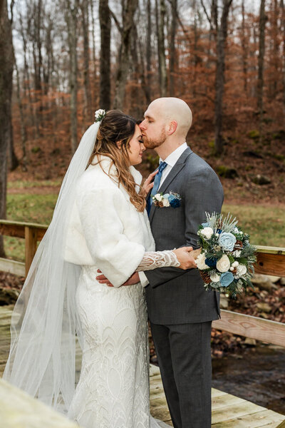 Groom gently kissing his bride on the forehead outside