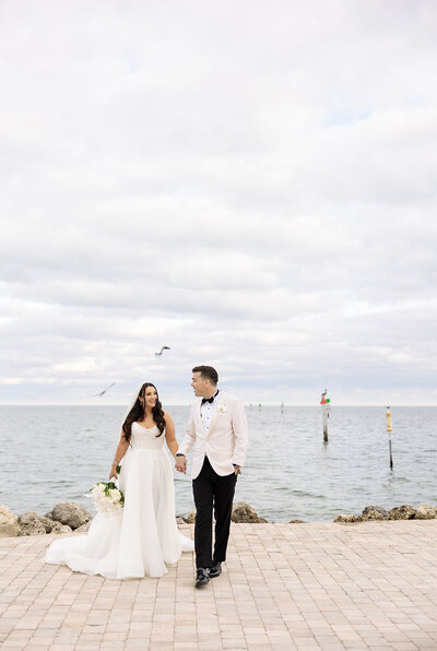 A close-up of the bride and groom figurine wedding cake topper, surrounded by delicate white orchids, at Ocean Reef, Key Largo.