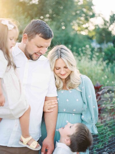 Family in garden sunset smiling at one another by Portland Family Photographer Emilie Phillipson Photography. 