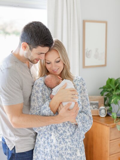 newborn baby being held by mom and dad during boston newborn photography session