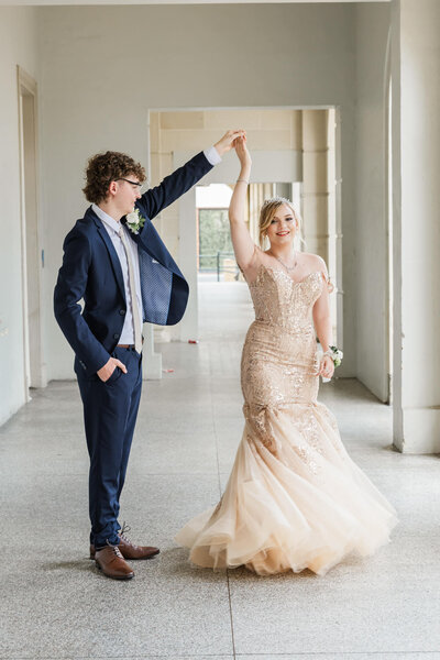Guy spinning girl around, wearing stunning formal outfits, at heritage listed former post office, East Street, Rockhampton.