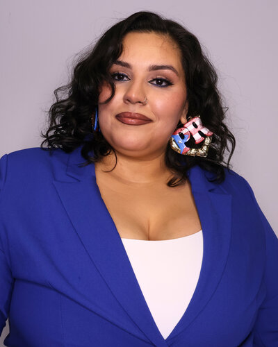 Amanda the Creative Cool Mom Behind Millien Media in a blue blazer with gold bamboo puerto rican flag earings