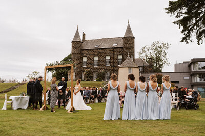 Bride and bridesmaids laughing under confetti at aswanley wedding venue
