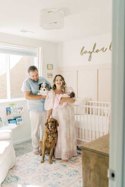 New family of three hold smile for  photos with their dogs