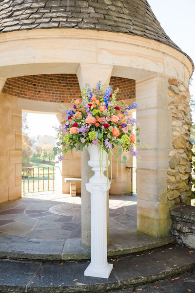 Full length photo of flower urn arrangement with purple and peach flowers Graylyn Estate Wedding