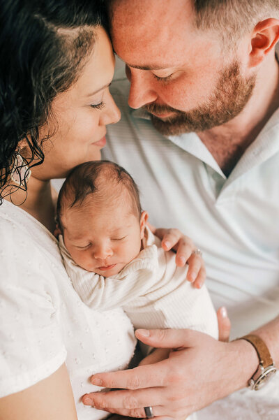 Father and Daughter holding baby in armchair