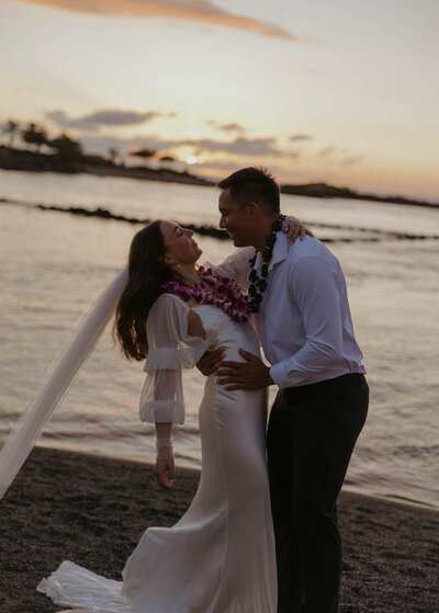 destination elopement photography  in Hawaii bride and groom laughing eloping on the beach