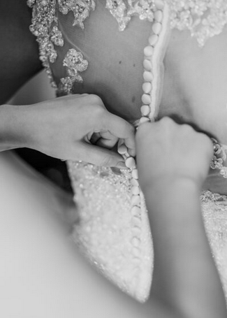 buttoning the brides wedding dress
