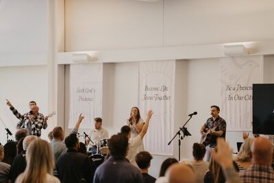 People worshiping from stage with arms raised