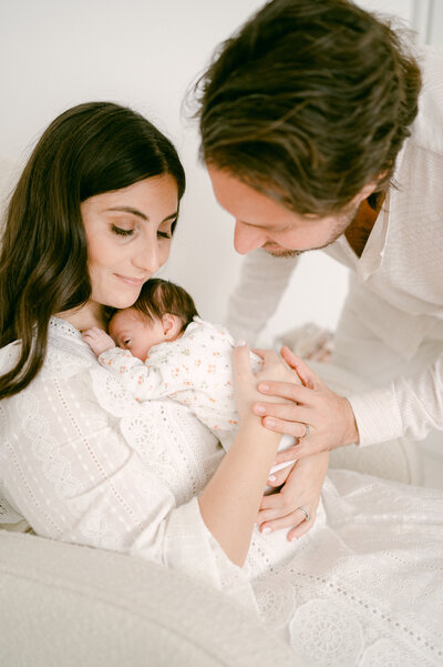 Dad and mom holding newborn baby by Miami Newborn Photography