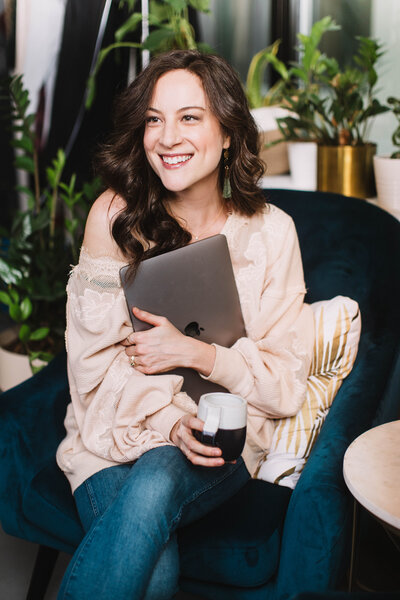 woman smiling holding computer
