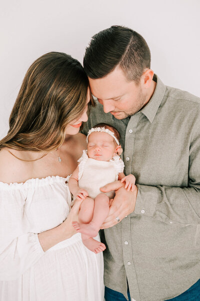 Joplin MO motherhood and family photographer captures parents holding newborn baby girl