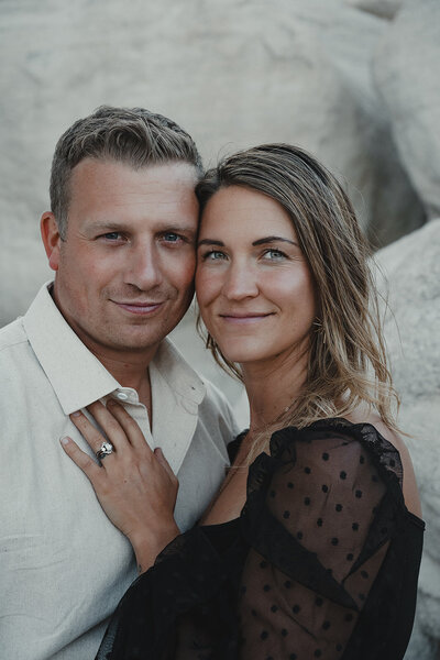 A gorgeous, blonde hair blue-eyed couple stands with their foreheads together during a photography session in the Colorado paint mines.