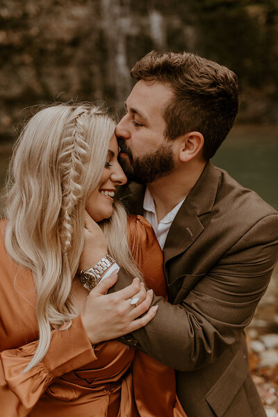 Couple embracing and man kissing woman on the forehead