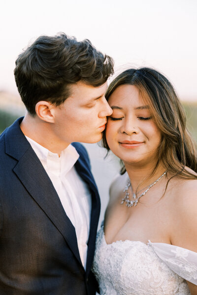 hilton head wedding photo on the beach with groom kissing brides cheek