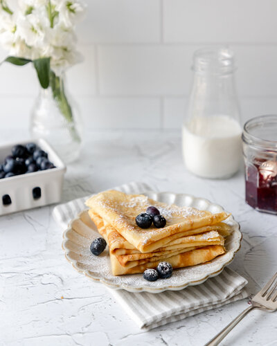 a stack of crepes with blueberries on top