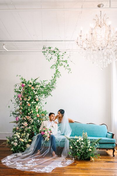 Large floral installation and couple on blue couch
