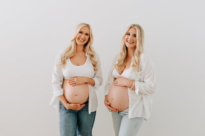 Capture the beauty of sisterhood and shared motherhood with a heartwarming maternity session featuring two expecting sisters. These radiant siblings joyfully showcase their baby bumps in a serene and beautifully captured photoshoot. Celebrate the bond between sisters as they embrace their simultaneous pregnancies in a charming and intimate setting. Professional maternity photography that portrays the unique connection and anticipation shared by two pregnant sisters, creating timeless memories for both families.