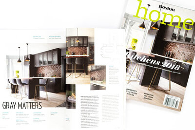 Boston Home Magazine's kitchen edition cover features our Westwood project. A contemporary space with dark grey cabinets and unique copper tile, designed for ultimate entertainment.